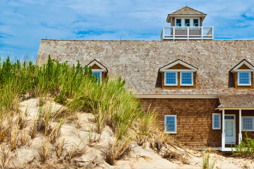 Cedar shingle roof in the Outer Banks with sand dune in front.
