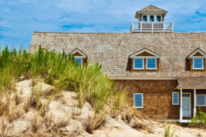 Cedar shingle roof in the Outer Banks with sand dune in front.