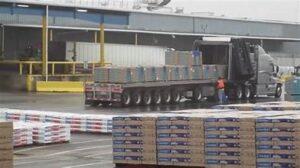 Flatbed truck carrying a load of roofing shingles, representing rising roofing material costs